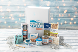 Collection of Achill Island Sea Salt products on a wooden surface with a festive background.