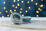 Ceramic pinch pot labeled 'Achill Island Sea Salt' on a marble surface with a blurred light background