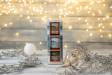 Achill Island Sea Salt Trio gift box on a wooden surface with decorative elements and blurred lights in the background