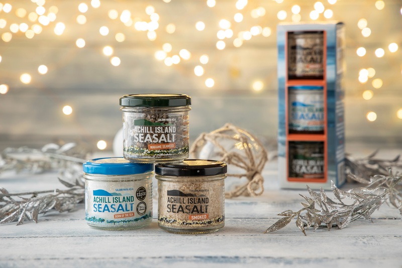 Achill Island Sea Salt containers on a wooden surface with decorative lights in the background