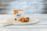 Box of Achill Island Sea Salt Caramel Fudge on a marble board with fudge pieces.