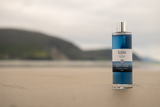 Bottle of Saile Blue Bath soak sitting on Keel beach